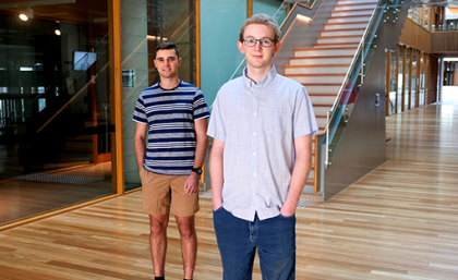 Two men standing in front of a staircase 